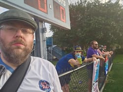 Soccer Zombie Tom Franklin with the rag tag St. Petersburg Social Club supporters group of USL2's St. Petersburg FC. Some social club members have masks on as they stand under a scoreboard.